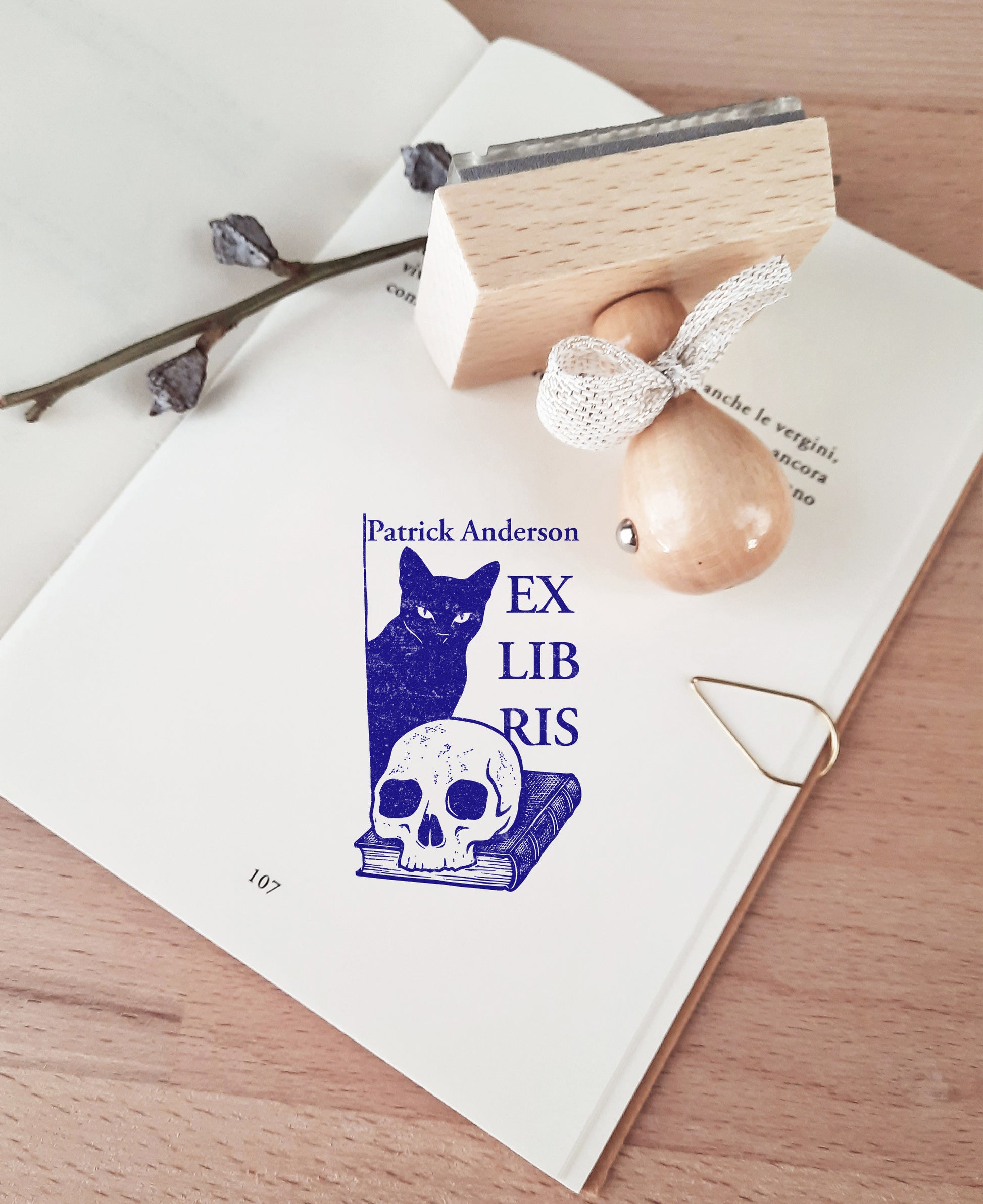 Custom book stamp with a Memento Mori design featuring a black cat, a skull, and a book. This is an high-quality, personalized wood rubber stamp, with  handmade wooden handle wrapped with a decorative ribbon, highlighting a unique, luxury gift for book collectors, avid readers, and personal library enthusiasts.
custom book stamp
Memento Mori design
personalized wood rubber stamp
Ex Libris
book collectors
luxury gift for book lovers