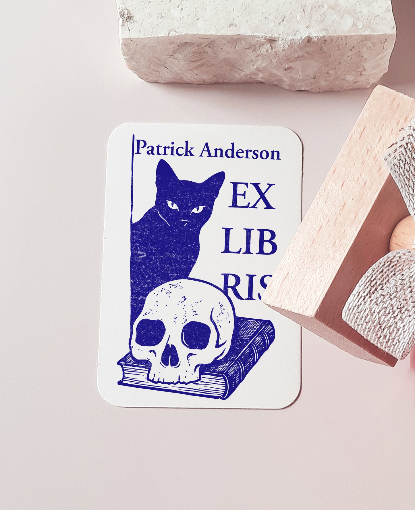 Custom book stamp with a Memento Mori design featuring a black cat, a skull, and a book. This is an high-quality, personalized wood rubber stamp, with  handmade wooden handle wrapped with a decorative ribbon, highlighting a unique, luxury gift for book collectors, avid readers, and personal library enthusiasts.
custom book stamp
Memento Mori design
personalized wood rubber stamp
Ex Libris
book collectors
luxury gift for book lovers