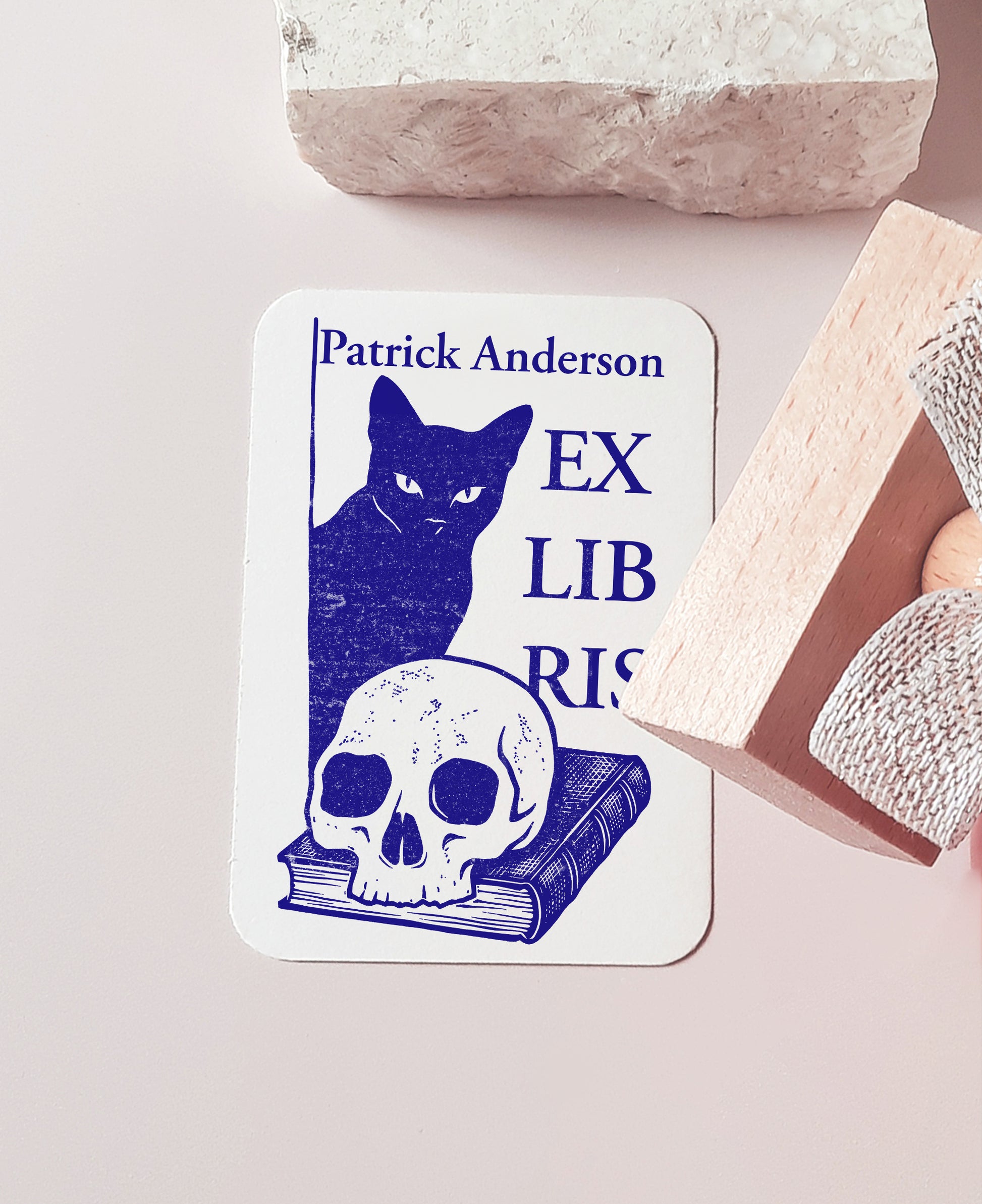 Custom book stamp with a Memento Mori design featuring a black cat, a skull, and a book. This is an high-quality, personalized wood rubber stamp, with  handmade wooden handle wrapped with a decorative ribbon, highlighting a unique, luxury gift for book collectors, avid readers, and personal library enthusiasts.
custom book stamp
Memento Mori design
personalized wood rubber stamp
Ex Libris
book collectors
luxury gift for book lovers