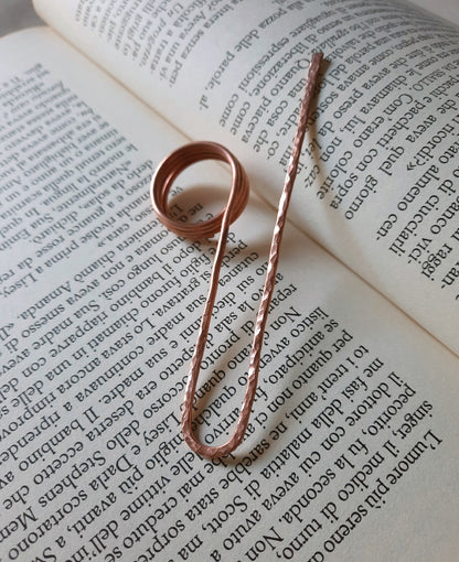 Handmade hammered copper ring bookmark resting on an open book