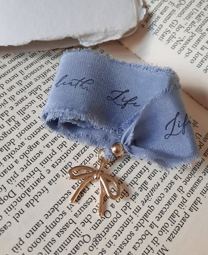Handmade silk bookmark with gold bow charm on one side and tree seal detail on the other